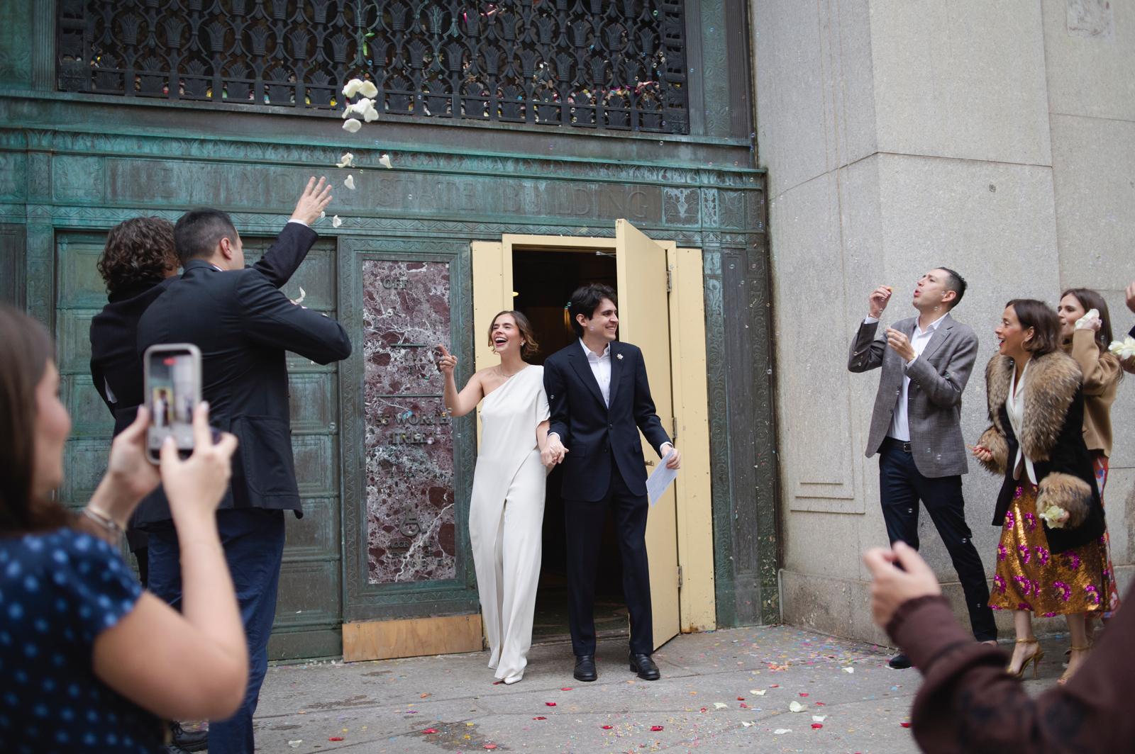 Irene y Javier saliendo de la ceremonia entre confeti y flores, celebrando con sus seres queridos